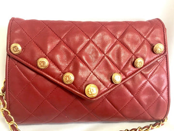 CHANEL Vintage red lamb leather shoulder bag with golden CC button motifs at flap