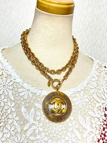 CHANEL Vintage golden necklace with a large cutout round CC mark pendant top